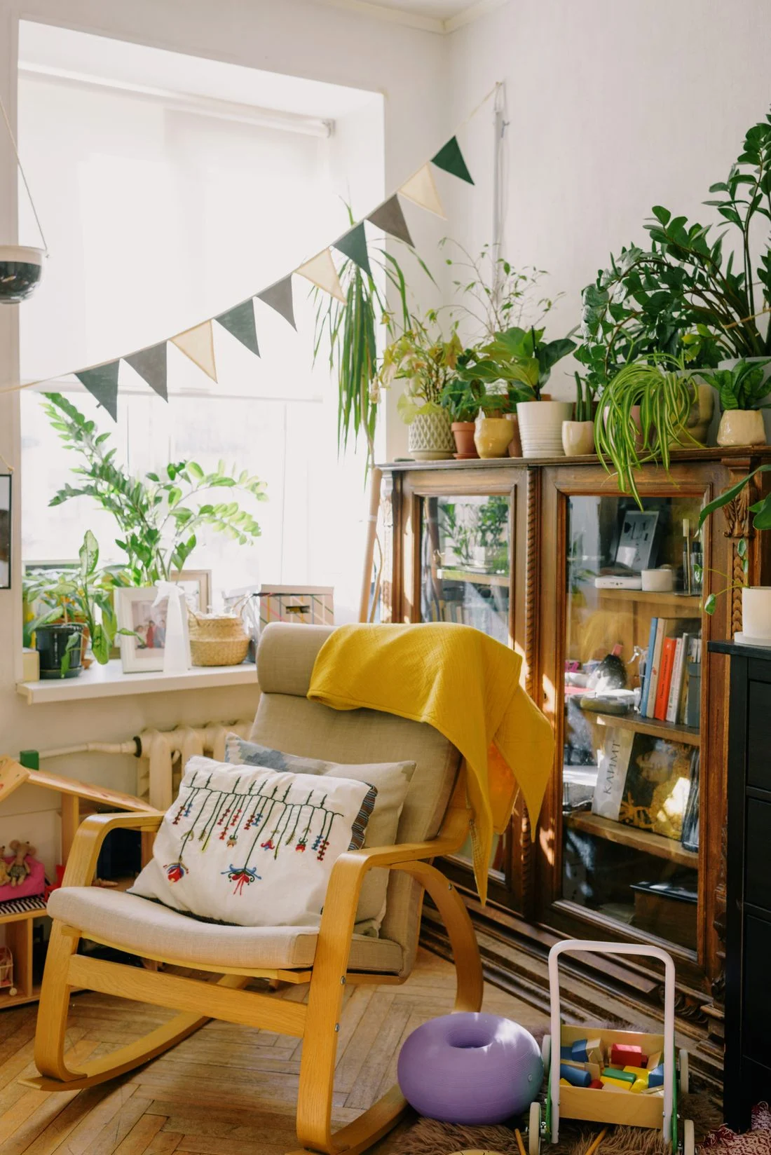 Wooden armchair beside a bright window and bookcase