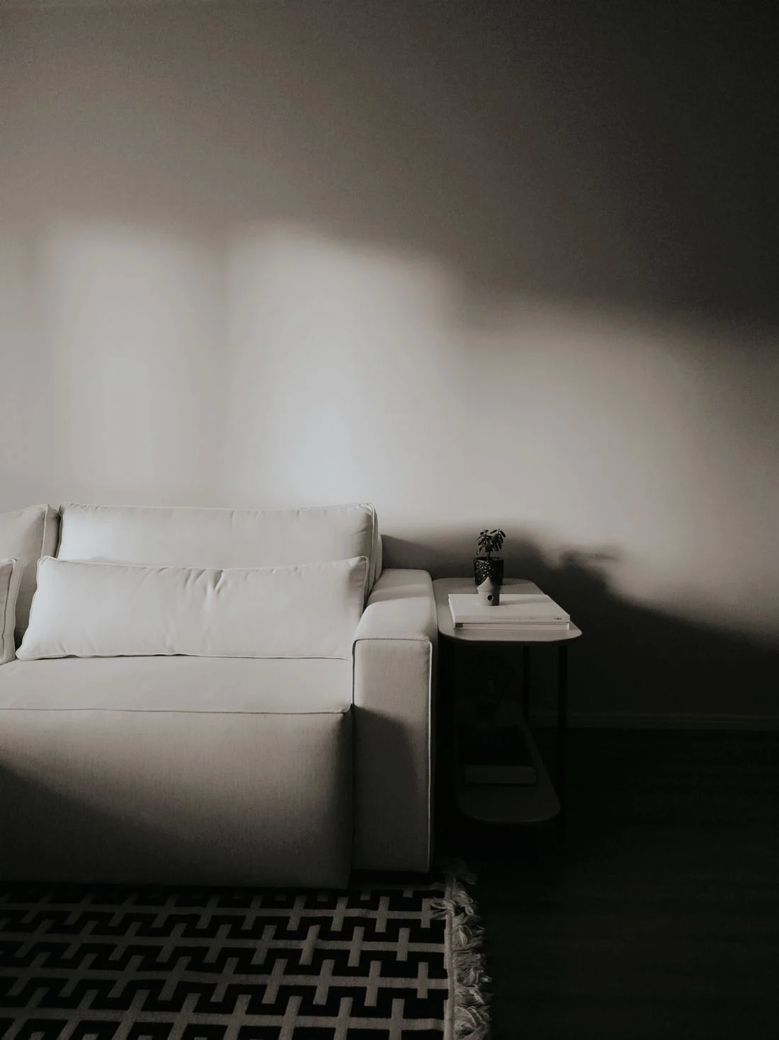 White sofa resting partly on a black and white patterned rug
