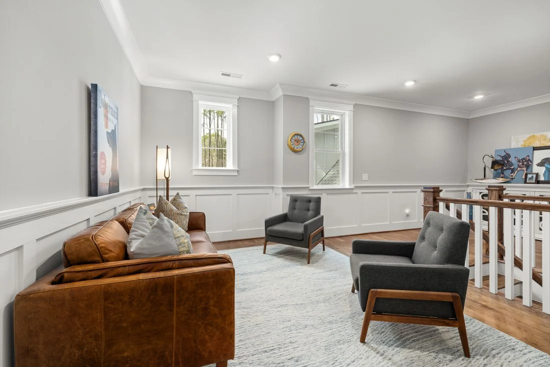 Leather sofa facing two armchairs in a bright living room