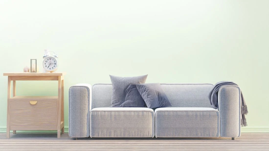Gray sofa with a wooden drawer unit beside it