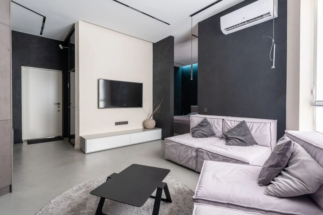 Pale sectional sofa facing a wall-mounted television