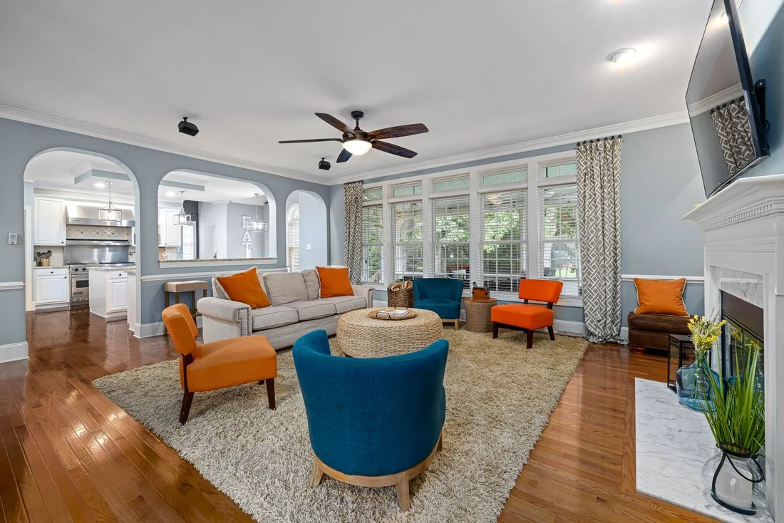 Living room with orange chairs, blue upholstery, and light walls