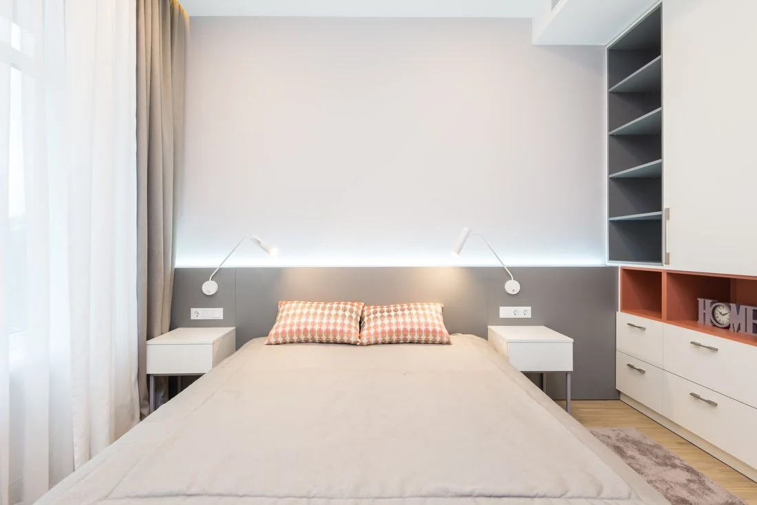 Bed framed by different storage arrangements on each side