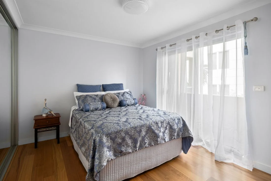 Blue patterned bedding in a white-walled bedroom