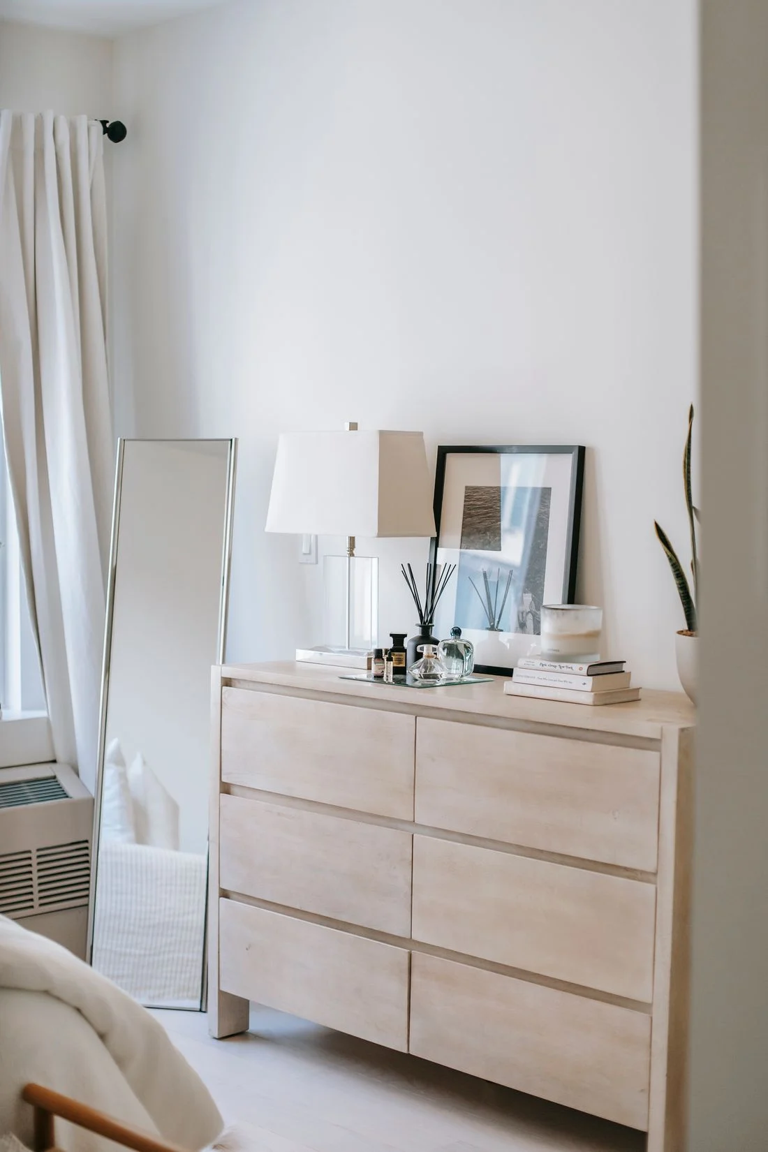Wooden chest of drawers with a mirror and small personal objects