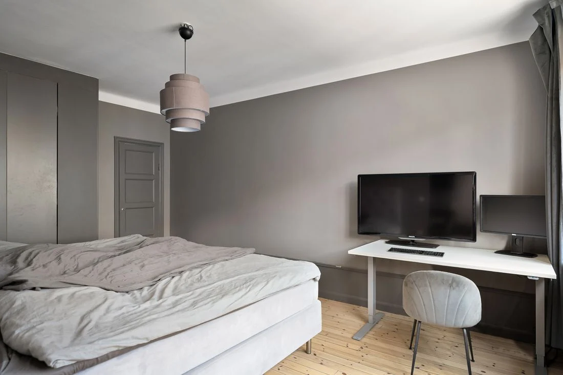 Bedroom desk with monitor placed beside the bed