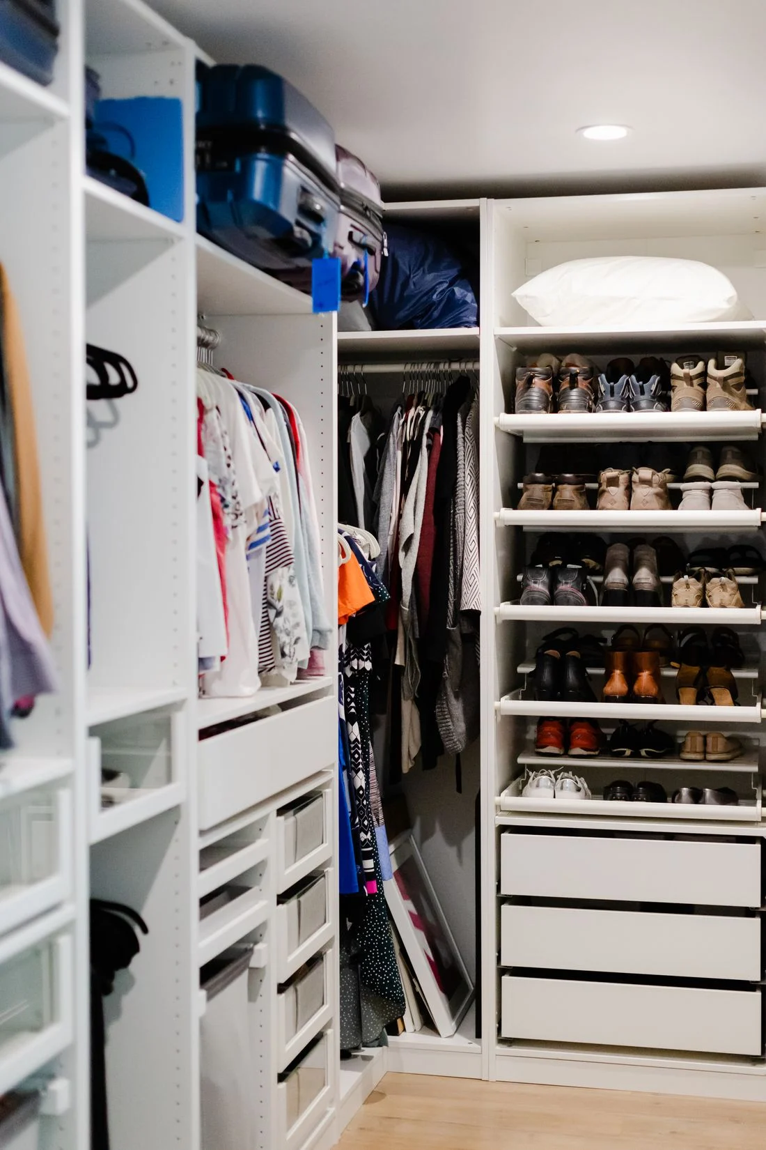 Organized walk-in closet with clothes and shoe shelves