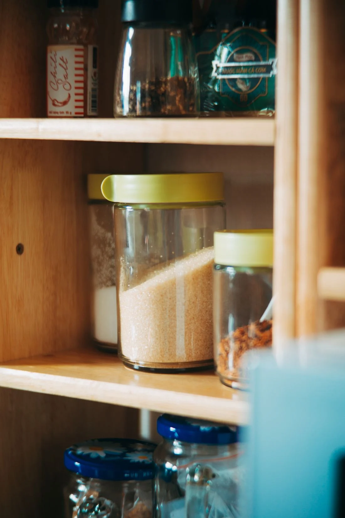 Ingredient jars arranged on wooden pantry shelves