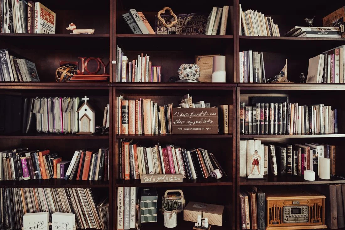 Books and personal ornaments on wooden shelves