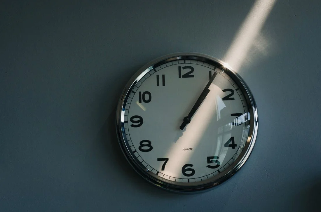 Round wall clock caught in sunlight