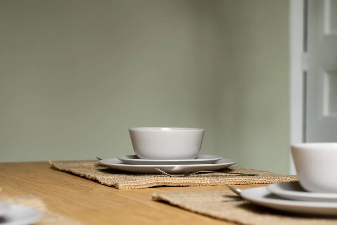 Simple white ceramic dinnerware on a wood table