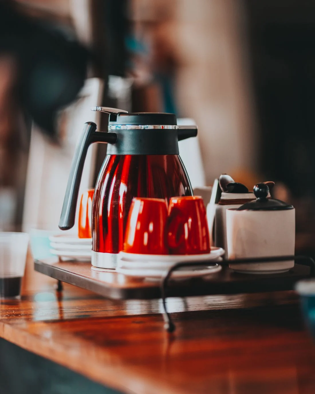 Red kettle and cups on a wooden tray
