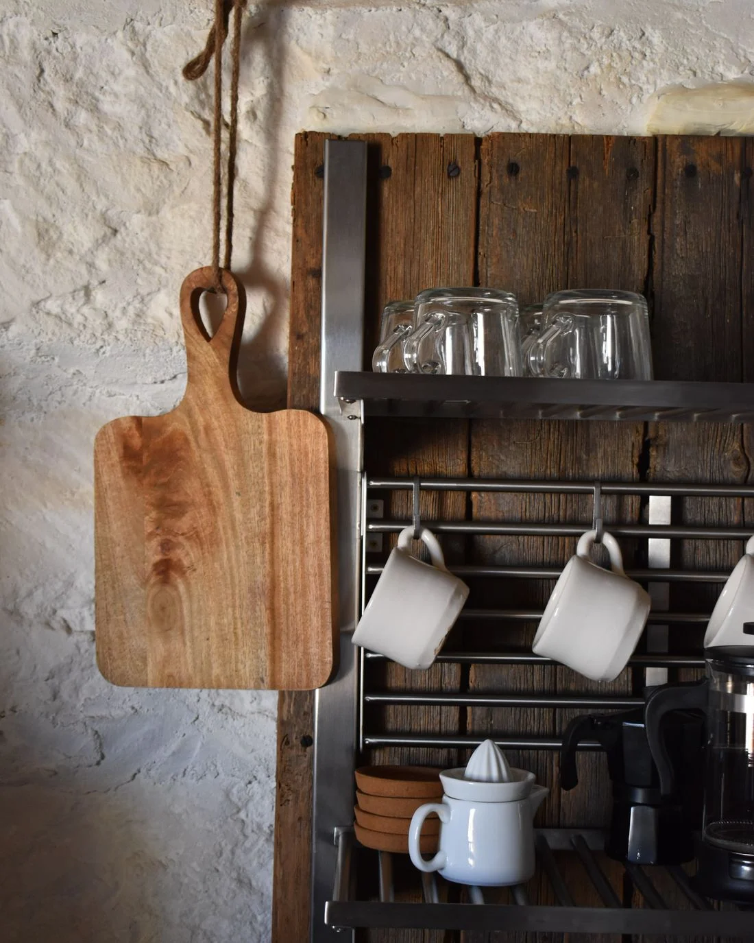 Mugs and glassware on a kitchen wall rack